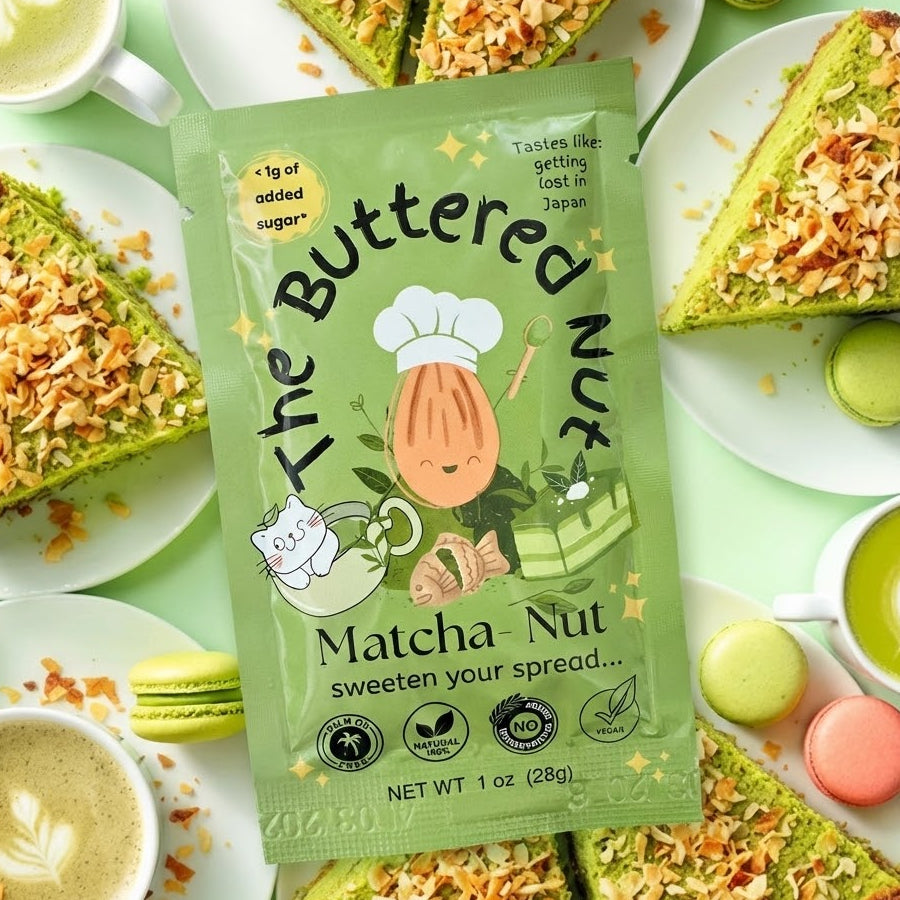 Green packet of 'The Buttered Nut's Matcha Nut' on a table with green tea and cookies.